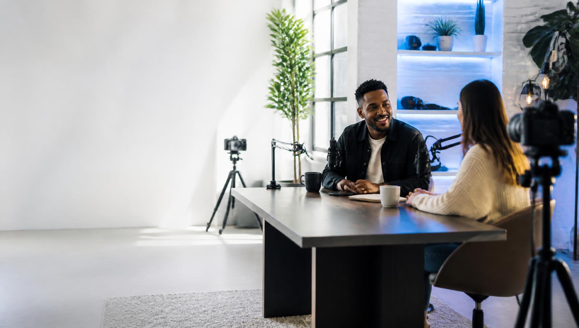 Two people recording a podcast in a bright studio